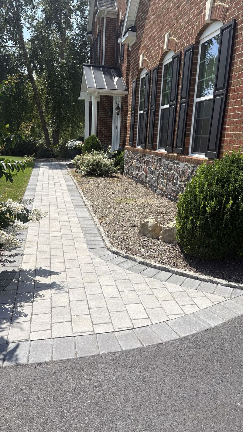Paver walkway with a charcoal border along fresh plantings and mulch