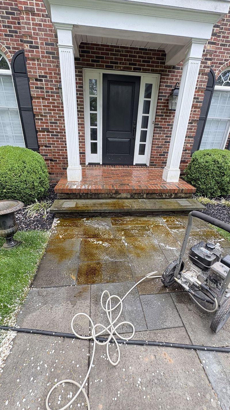 Bluestone walkway halfway through pressure washing, one side still stained
